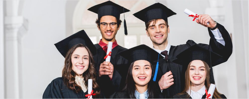 group diverse grads throwing caps up sky 12